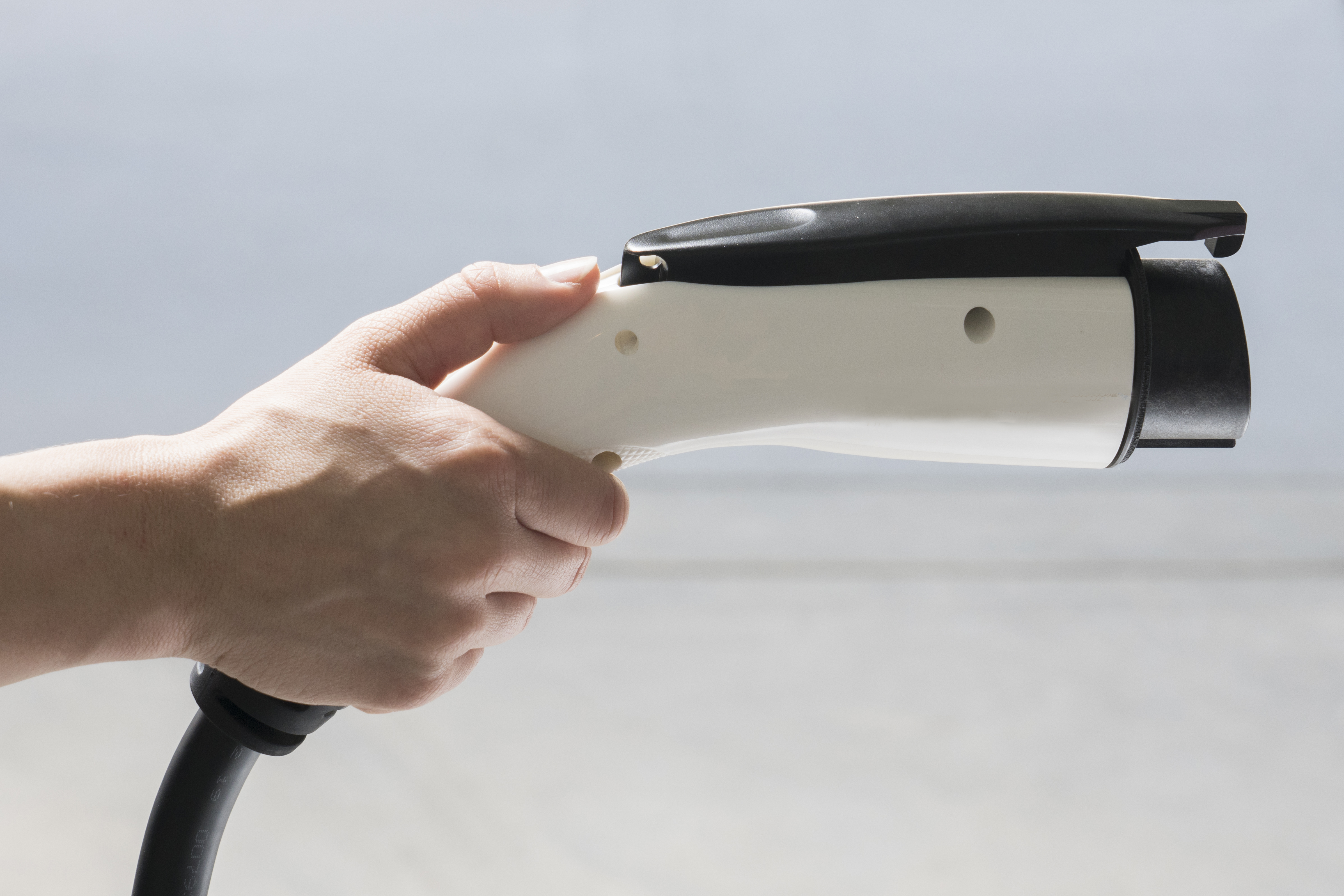 Hand holding and EV plug